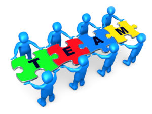 Royalty-free 3d computer generated clipart picture image of a team of 8 blue people holding up connected pieces to a colorful puzzle that spells out "team," symbolizing excellent teamwork, success and link exchanging.